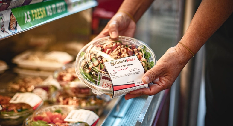 Close-up of a person holding a freshly prepared poke bowl from Sushiboi.